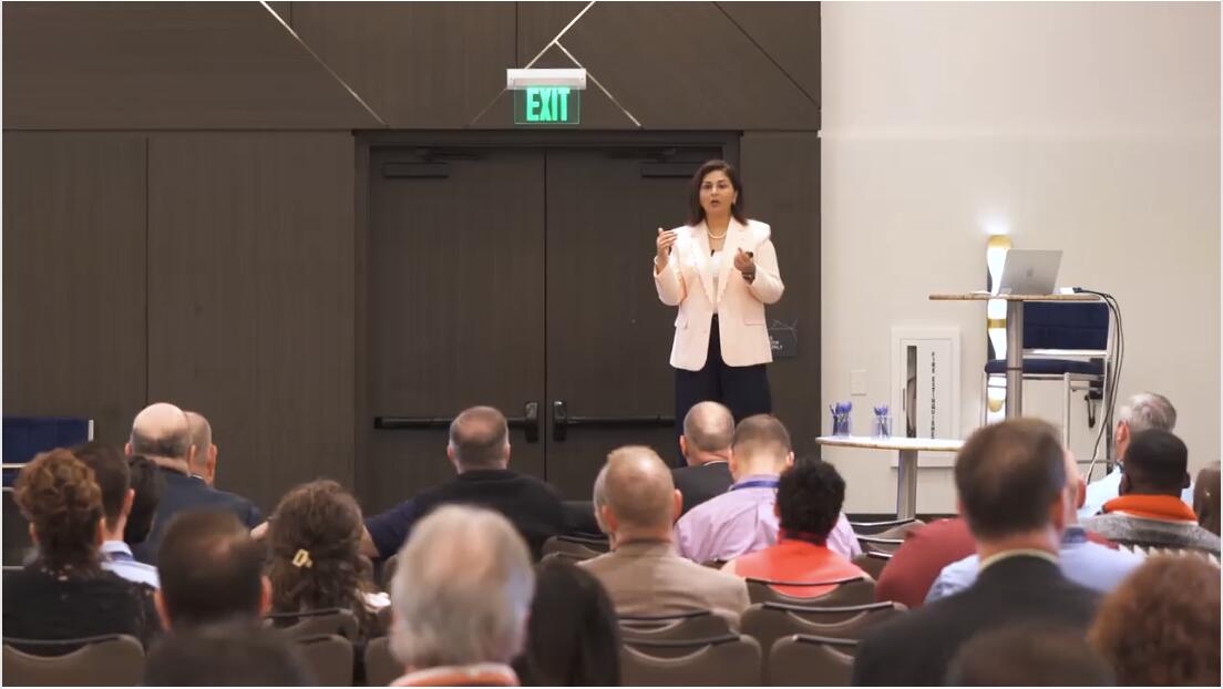 Meghna Roy speaking to an audience at a professional event